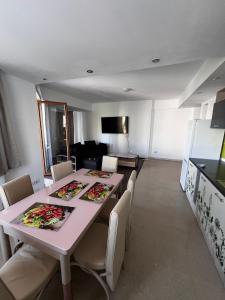 Un comedor con mesa y sillas y una cocina. en Apartament Flammarion, en Oradea