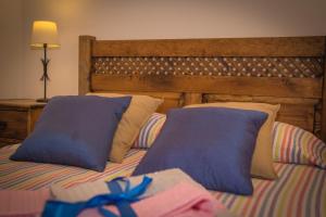 Una cama con dos almohadas azules encima. en Casa da Fecha, en Parada