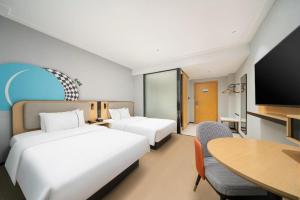 a hotel room with two beds and a table at City Comfort Inn Nanning Normal University Changgang Road Metro Station in Nanning +215 photos