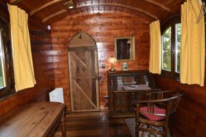 a wooden cabin with a desk and a wooden door at Yourte Roulotte et Gite de la Laïta in Clohars-Carnoët