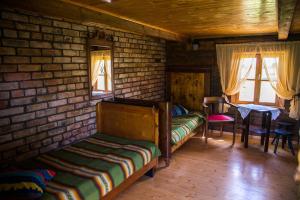 a room with two beds and a table and windows at Ērgļi in Bernāti