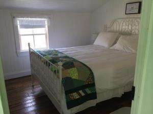 a bedroom with a large bed with a window at The Old Salt Box Co. - Grandma Lilly's in Fogo