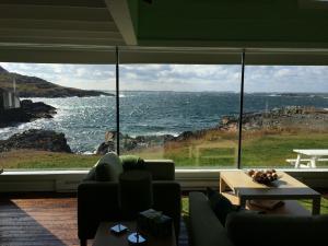 a living room with a large window looking out at the ocean at The Old Salt Box Co. - Grandma Lilly's in Fogo