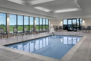 a swimming pool with chairs and tables and windows at TownePlace Suites by Marriott Sikeston in Sikeston