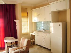 a kitchen with a refrigerator and a table and chairs at Gultepe Apartments in Kusadası