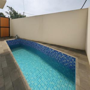 a swimming pool with blue tiles on the side of a building at Villa Royal Arois Unit C-01 in Batu