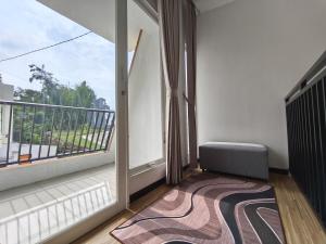 a room with a balcony with a large window at Villa Royal Arois Unit C-01 in Batu
