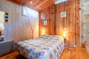 a bedroom with a bed in a wooden wall at La Poulido in Bédoin
