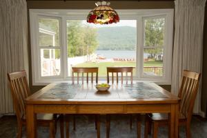 a dining room with a table and chairs and a window at Shore Meadows Lodge LLC in Lake George
