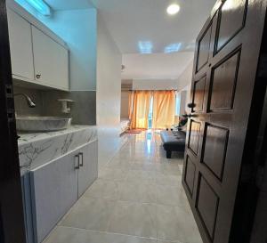 a kitchen with a door open to a living room at ATVR Juldis Tower Pratunam in Bangkok