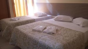 two beds with towels on them in a hotel room at Vila Santa Hotel in Aparecida +33 photos