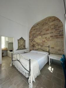a bedroom with a large bed with a brick wall at Corte Santa Maria B&B in Vasto