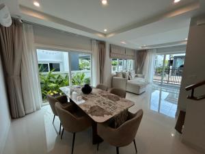 a dining room with a table and chairs and a living room at Supalai Rent BANG TAO PHUKET in Phuket