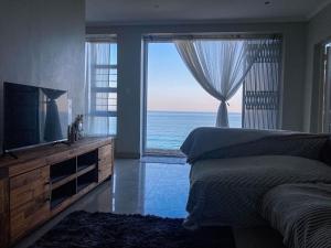 een slaapkamer met een bed en uitzicht op de oceaan bij AA Sea View in Durban