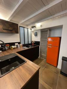 a kitchen with an orange refrigerator and a counter at Nid douillet - maison Spinola in Bastia