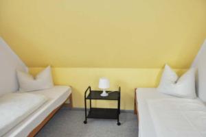 a room with two beds and a table with a lamp at Silbermöwe - Sonniger Balkon & Gartenidylle - perfekt mit Hund in Gollendorf