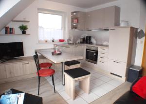 a small kitchen with a table and a counter top at Silbermöwe - Sonniger Balkon & Gartenidylle - perfekt mit Hund in Gollendorf