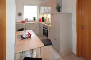 a kitchen with a wooden table and a counter top at Takelage - Sonniger Balkon & Gartenidylle - perfekt mit Hund in Gollendorf