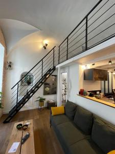 a living room with a couch and a staircase at Nid douillet - maison Spinola in Bastia +8 photos