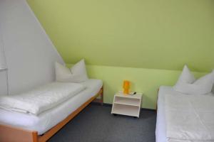 a room with two beds and a small white table at Takelage - Sonniger Balkon & Gartenidylle - perfekt mit Hund in Gollendorf