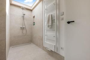 une salle de bain avec douche et porte vitrée dans l'établissement Luxus-Ferienhaus DS11, à Fehmarn 63 autres photos