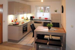 a kitchen with a table and a table and chairs at Seestern - Wassernah mit Garten und eingezäunter Terrasse in Gollendorf