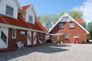 a house with a red roof and a white building at Seestern - Wassernah mit Garten und eingezäunter Terrasse in Gollendorf
