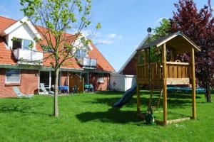 a playground in a yard next to a house at Seestern - Wassernah mit Garten und eingezäunter Terrasse in Gollendorf +5 photos