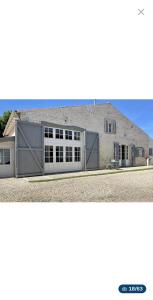 a large building with two garage doors in front of it at Chambre d'hote in Saint-Dizant-du-Gua