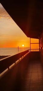 a person standing on a pier at the beach at sunset at Relax & Sea Apartment - Cabo Cervera - Torrevieja in Torrevieja