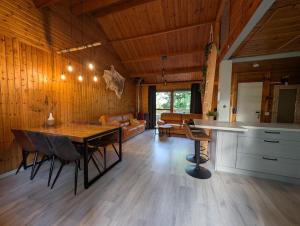 a kitchen and living room with a table and chairs at Chalet HEUREux in Somme-Leuze +92 photos