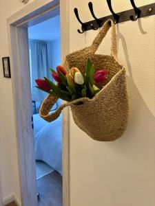 Ein Sack mit Blumen hängt an einer Wand. in der Unterkunft Ferienwohnung Nordig in Garding + 12 Fotos