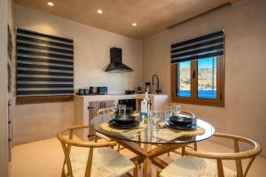 a dining room with a glass table and chairs at Gama luxury living in Symi +20 photos