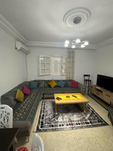 una sala de estar con un sofá y una mesa en Cosy appartement, en Sousse