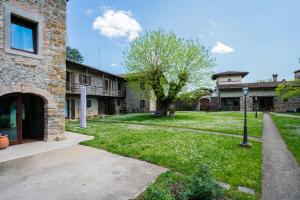 a building with a yard with a tree and a street light at Ca' Tonero in San Giovanni al Natisone