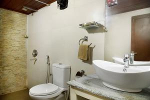 Un baño con un inodoro blanco y un lavabo. en Ibex Resorts, Valparai Tale Rock, en Vālpārai 20 fotos más