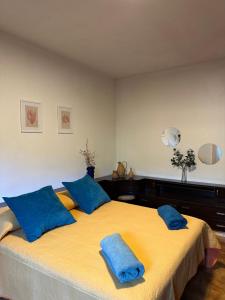 a bedroom with a large yellow bed with blue pillows at La Ghiandaia in Porto Ercole