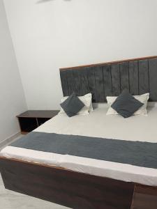 a large bed with black and white sheets and pillows at Shivaay Residency in Varanasi