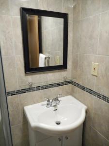 La salle de bains est pourvue d'un lavabo et d'un miroir. dans l'établissement Hotel Victor, à Montréal
