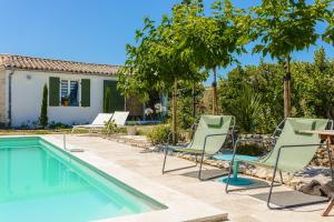 een zwembad met stoelen en een tafel en een huis bij Escapades Océanes in Sainte-Marie-de-Ré