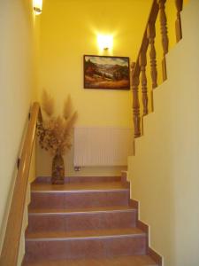 un escalier avec un tableau et un vase de fleurs dans l'établissement House Mara, à Korenica