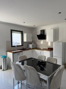 a kitchen with a black table and chairs at Maison de la Pornicaise 13 in Saint-Jean-de-Monts
