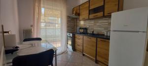 a kitchen with a table and a white refrigerator at Comfortable Thermi apartment near SKG Airport in Thérmi