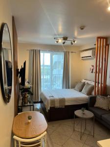 a bedroom with a bed and a couch and a table at TheSimsCozyPlace in Lapu Lapu City +9 photos