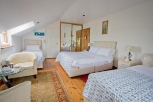 1 dormitorio con 2 camas, sofá y silla en Rosdarrig Bed & Breakfast, en Boyle