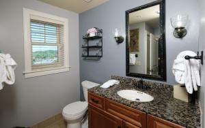 a bathroom with a sink and a toilet and a mirror at The Smoky Mountain Nest in Pigeon Forge +9 photos