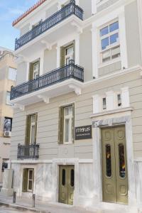 a white building with balconies on top of it at Morus Acropolis Boutique Hotel in Athens