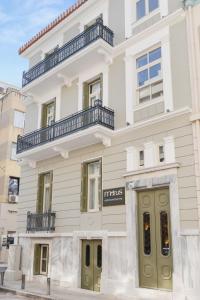 a white building with green doors on a street at Morus Acropolis Boutique Hotel in Athens