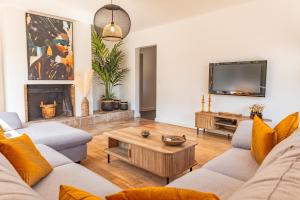 a living room with a couch and a tv at Villa Lisa Porto-Vecchio in Porto-Vecchio