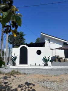 a white building with three birds sitting on the ground at Rumah Petak Melor Muji Concept in Melur